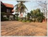 Lao style house with large garden next to rice paddy field