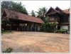 Lao style house with large garden next to rice paddy field