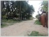 Lao style house with large garden next to rice paddy field